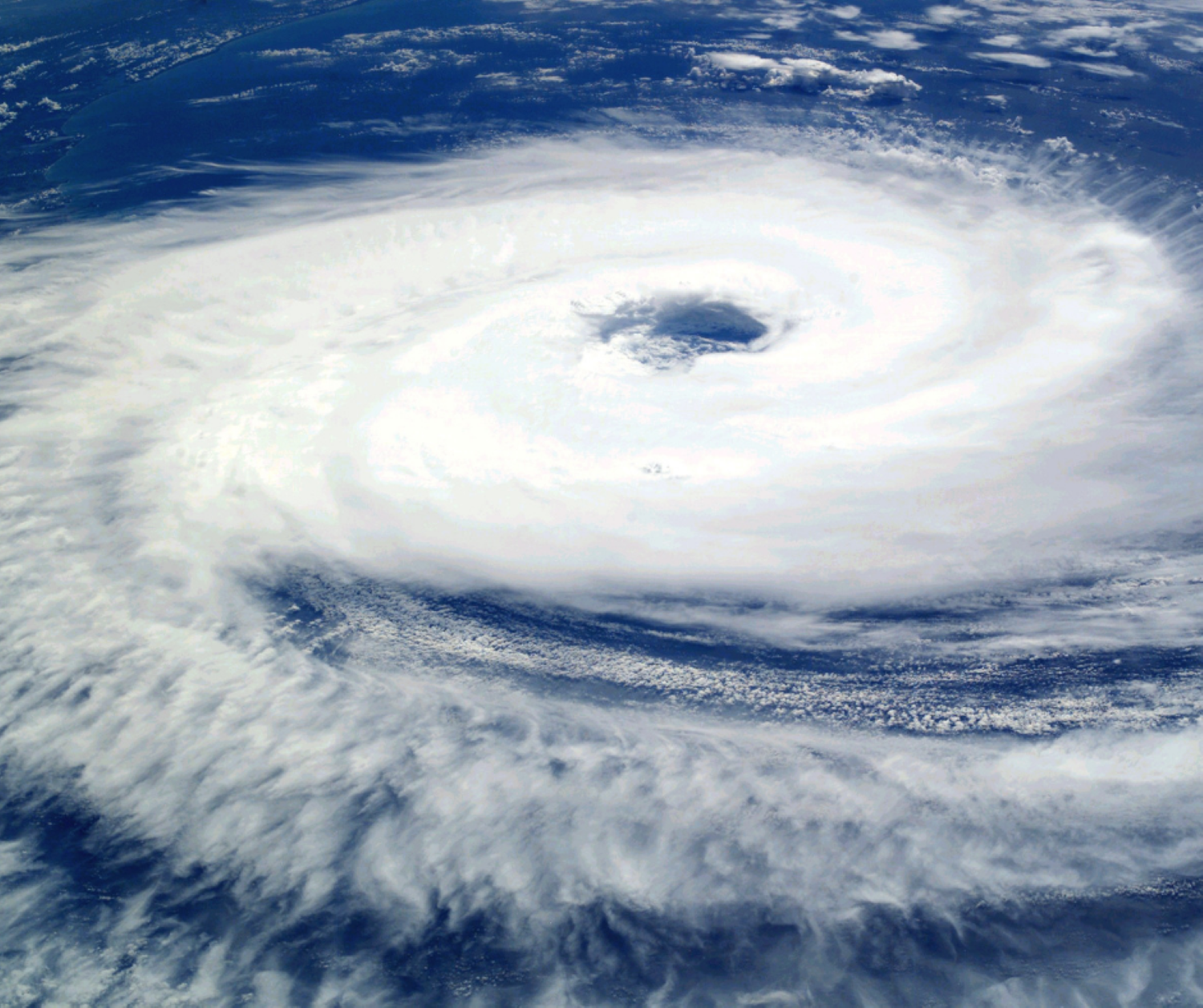 Aerial view of a large hurricane over the ocean, showing a well-defined eye at the center surrounded by spiraling cloud bands.